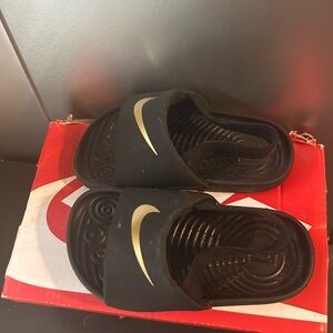 Black and gold baby Nike slides